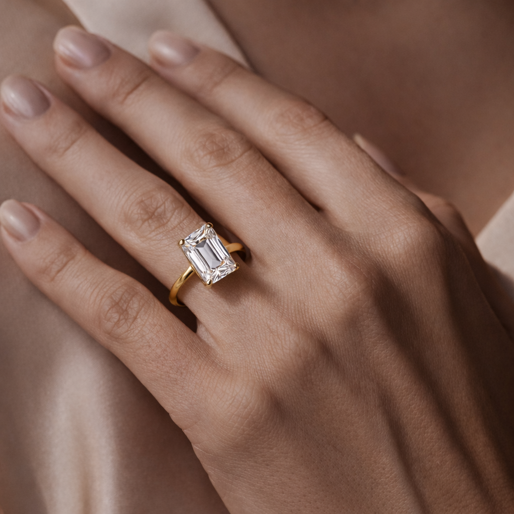 Solitaire Emerald Cut Diamond Ring worn on hand in 18K Yellow Gold