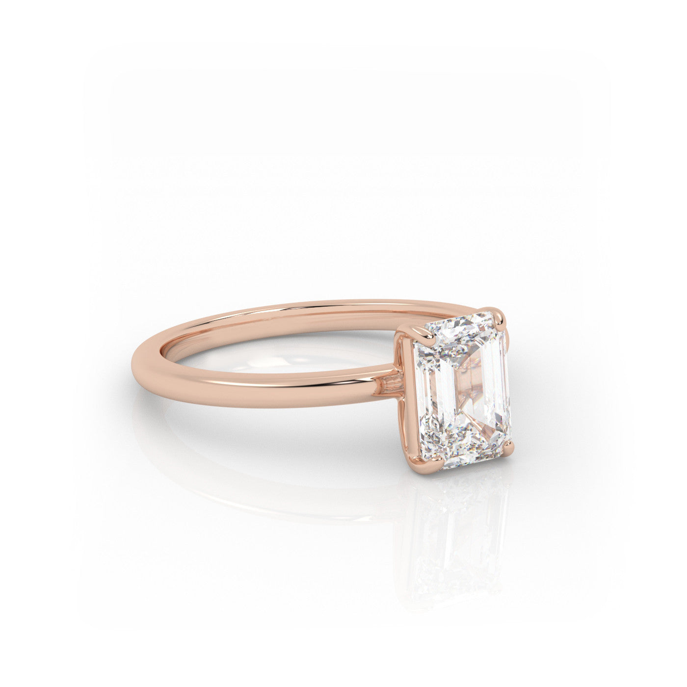 angled view of Solitaire Emerald Cut Diamond Ring in 18K Rose Gold