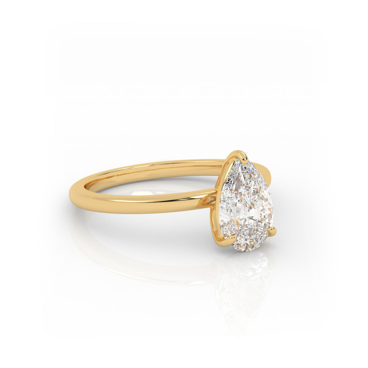 Angled view of pear cut solitaire diamond engagement ring in 18K yellow gold